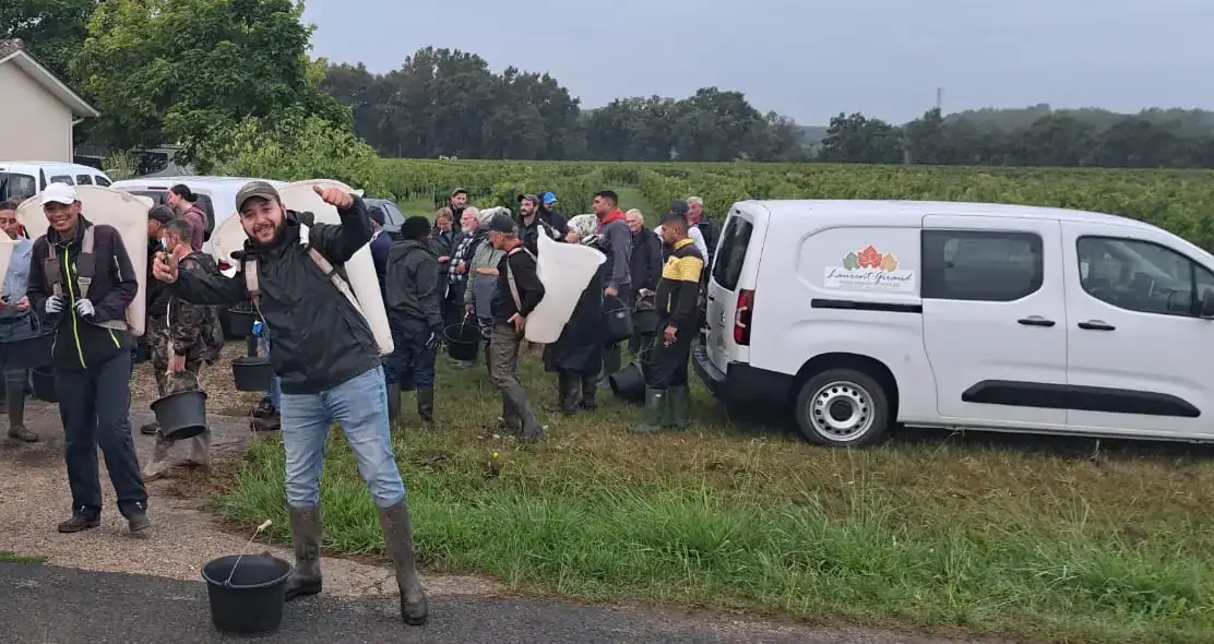 Équipe de vendangeurs de Laurent Giraud avec hottes et seaux au bord des vignes avant une journée de vendanges manuelles